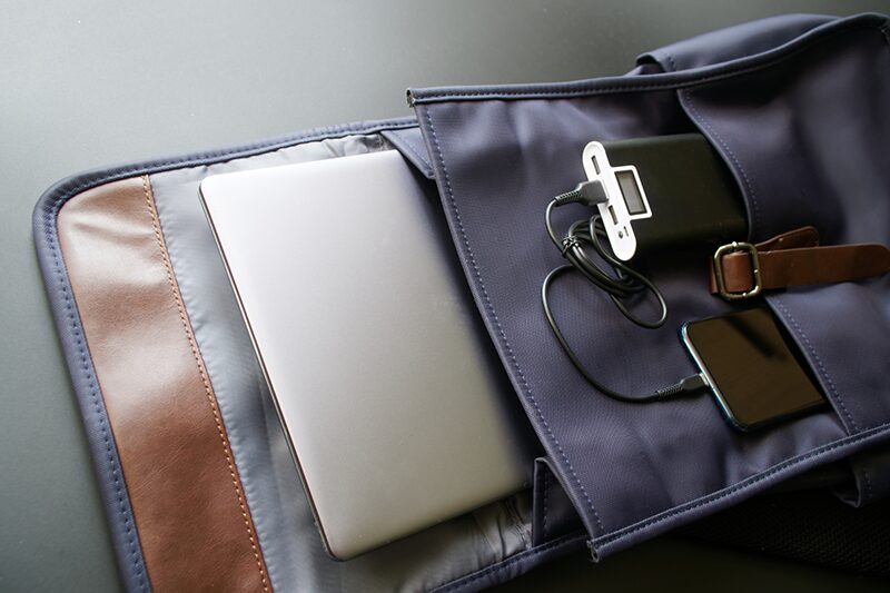 A neatly organized bag containing essential electronic devices and accessories arranged in a clean, minimalist layout.
